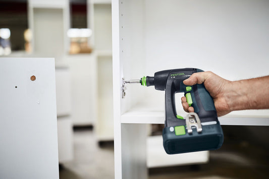 Festool C 18 Akku-Bohrschrauber bei der Anwendung an Wanddose, kompakte Bauform in Hand