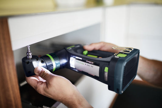 Festool C 18 Akku-Bohrschrauber mit Akku und Systainer in einer Hand gehalten, kompakte EC-TEC Bauform