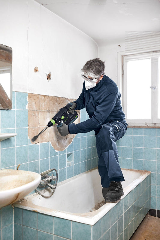Festool KHC 18 EB Kombihammer beim Meißeln an Fliesen in Badezimmer mit Schutzbrille