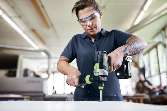 Festool QUADRIVE TPC 18/4 Akku-Schlagbohrschrauber in Anwendung beim Bohren in Mauerwerk mit Schutzbrille