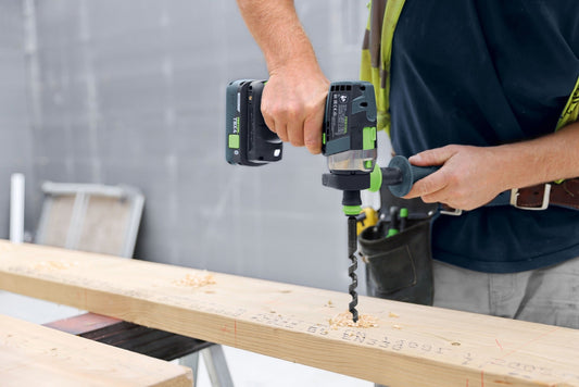 Festool Akkubohrschrauber mit BP 18 TBX 4 Akkupack beim Bohren in Holz, Wechsel des Akkupacks demonstriert.
