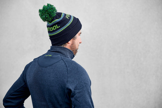 Festool Bommelmütze WINH-FT1 Dunkelblau mit grünem Bommel, von hinten getragen auf Person mit Fleecejacke