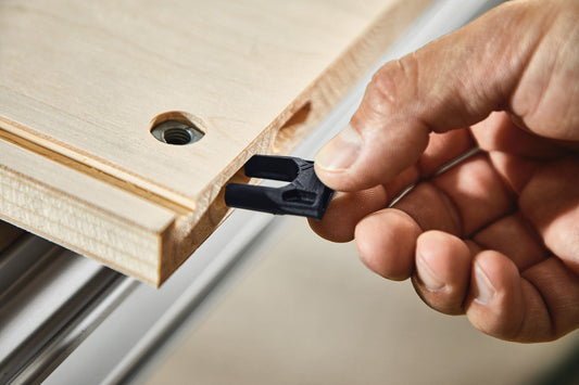 Festool Eckverbinder KV D8 wird in Holzplatte eingesteckt, schwarzer Kunststoffkeil wird von Hand eingesetzt