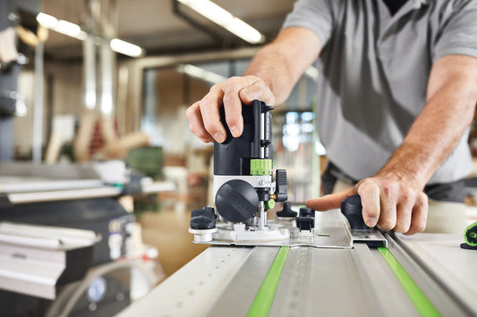 Festool Führungsschiene FS/2 mit Gummilippe auf Werkstück, Handgriff und Nivellierschiene im Einsatz in Werkstatt.