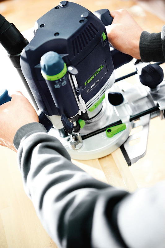 Festool OF 2200 EB Oberfräse in den Händen eines Anwenders beim Fräsen auf Holzwerkstück