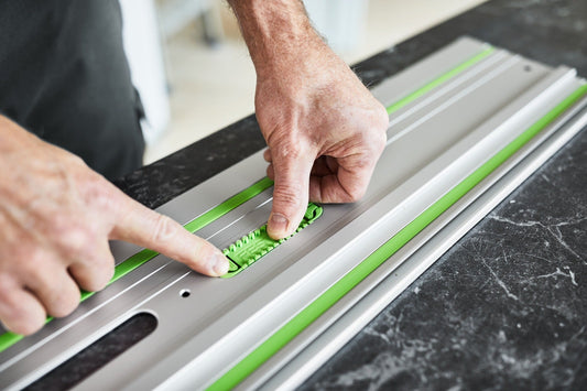 Festool Führungsschiene mit grünem Gleitbelag, Bedienung durch zwei Hände beim Positionieren auf Werkstück