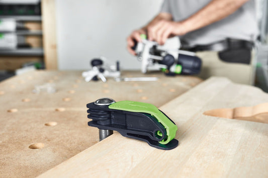 Festool Hebelzwinge MFT-HZ 80 mit grünem Klemmhebel auf Holzwerkstück, im Hintergrund Bediener mit weiteren Zwingen.