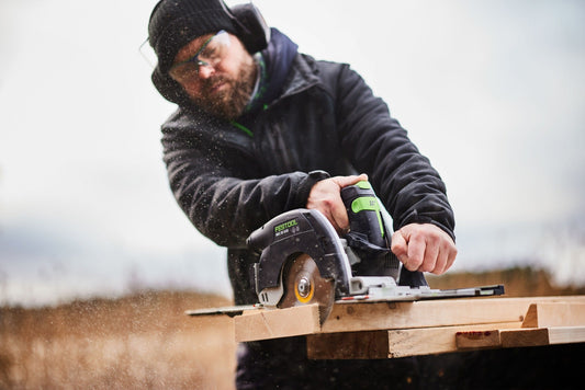 Festool HKC 55 Akku-Handkreissäge beim Längsschnitt in Holzbrett, Sägeblatt mit Funkenflug sichtbar