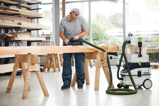 Festool HLC 82 Akku-Hobel mit Fasensohle FNS-HLC 82 beim Fasen eines Holzbalkens, Absauganlage angeschlossen.