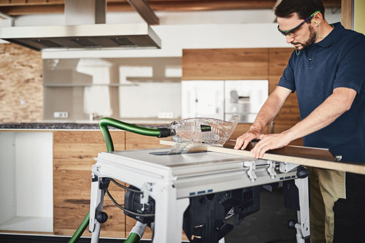Handwerker arbeitet mit Festool Kreissägeblatt WOOD UNIVERSAL HW an Holzwerkstoff, Absauganlage mit grünem Schlauch