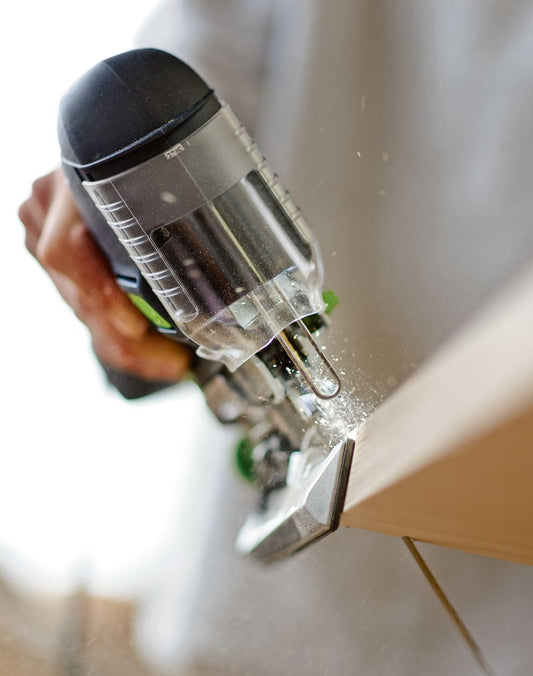 Festool Stichsäge PS 420 mit transparentem Staubabsaugbehälter beim Sägen in Holzwerkstück