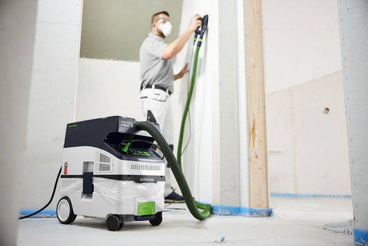 Festool CTH MIDI I AC Absaugmobil mit grünem Schlauch bei Trockenarbeiten auf Baustelle in Anwendung