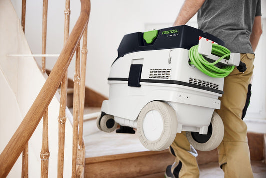 Festool CTL 26 EI-FLR Absaugmobil mit grünem Kabel, auf Baustelle neben Holztreppe einsatzbereit