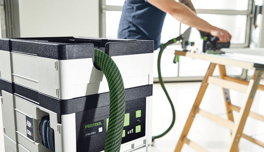 Festool CTMC SYS I Akku-Absaugmobil mit grünem Absaugschlauch in Werkstatt bei Holzbearbeitung