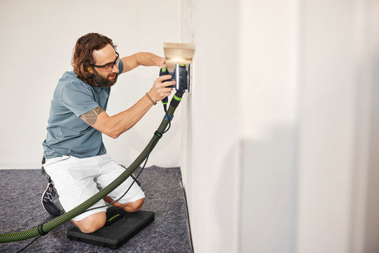 Festool Sitzkissen SK-CT/SYS in Anwendung bei Wandarbeiten, Handwerker kniet ergonomisch auf gepolstertem Kissen