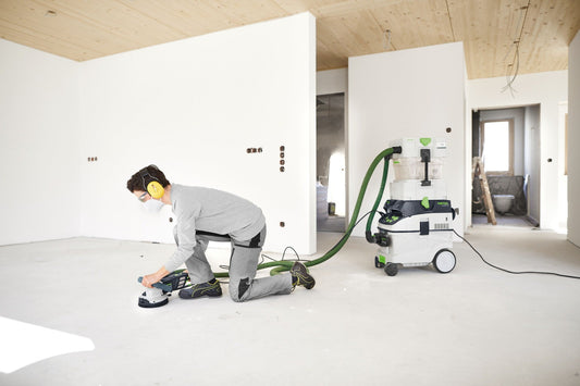 Festool Sanierungsschleifer RENOFIX RG 130 ECI in Anwendung mit Absauganlage beim Schleifen von Gipskartonwand