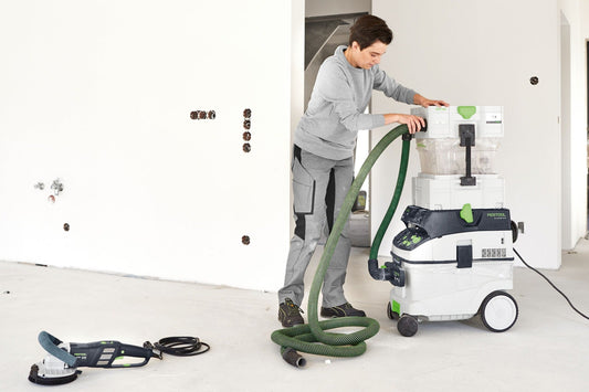 Festool CT-VA-20 Vorabscheider mit grünem Absaugschlauch bei Staubabsaugung von Gipskartonwand