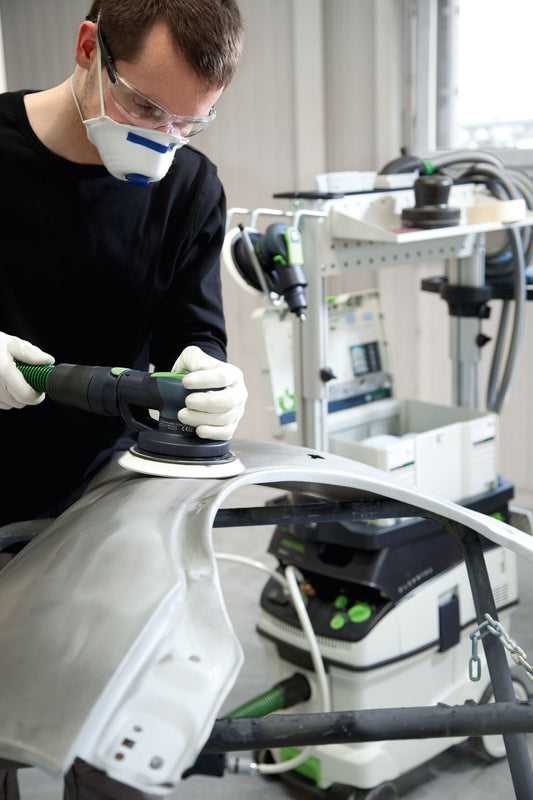 Festool LEX 3 150/5 Druckluft-Exzenterschleifer bei Anwendung auf weißem Werkstück mit Absauganlage