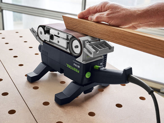 Festool BS 75 E-Set Bandschleifer beim Schleifen von Holzwerkstück auf Werkbank mit Lochraster