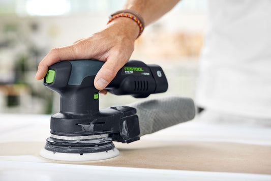 Festool Elektroschleiffer ETSC 125 mit grünem Schalter in Anwendung auf Holzoberfläche