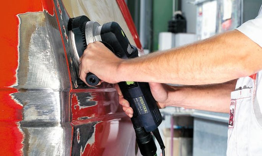 Festool Schleifteller in Anwendung auf rotem Werkstück mit Exzenterschleifer, Klettbelag sichtbar.