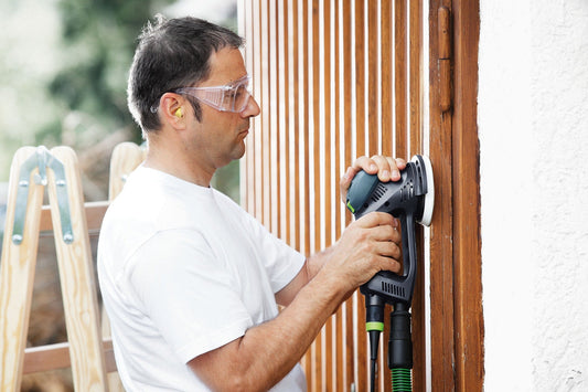 Festool ROTEX RO 125 FEQ-Plus Exzenterschleifer bei der Anwendung auf Holzoberfläche mit Schutzbrille
