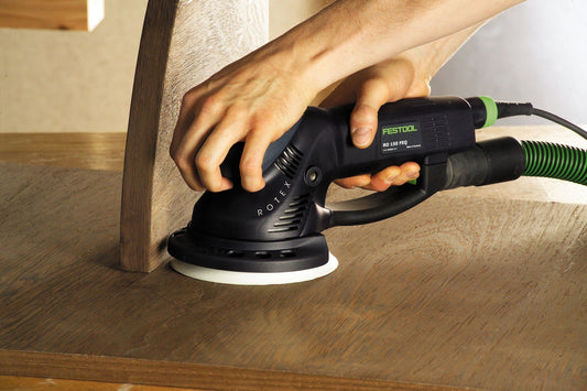 Festool ROTEX RO 150 FEQ-Plus Exzenterschleifer bei Anwendung auf Holzoberfläche mit Schleifteller