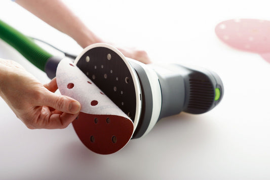 Festool Schleifscheiben Saphir mit StickFix-Klettsystem, rote und schwarze Schleifteller mit Lochung, in Hand gehalten