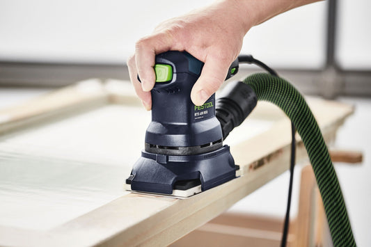 Festool RTS 400 REQ Protector beim randnahen Schleifen auf Holz-Werkstückkante mit grünem Absaugschlauch