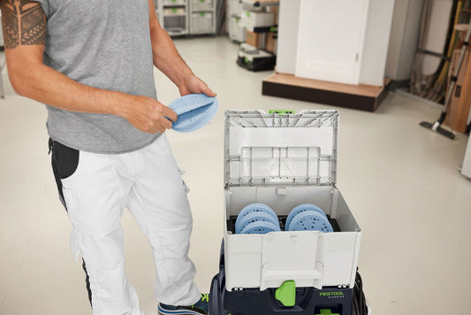 Festool Systainer³ SYS-STF D150 mit blauen Schleifmitteln Ø 150 mm in offener Box, Mann entnimmt Schleifpad