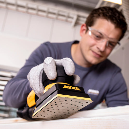 Mann verwendet Mirka Schleifmaschine mit Iridium Schleifpapier – präzises Schleifen von Holzoberflächen bei professioneller Anwendung im Innenausbau.