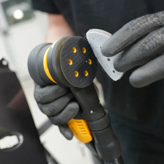Mirka Iridium Soft Schleifscheibe gelocht mit Grip-Befestigung wird auf Exzenterschleifer aufgebracht – staubarmes Schleifen mit Multifit-Lochung für optimale Absaugung.